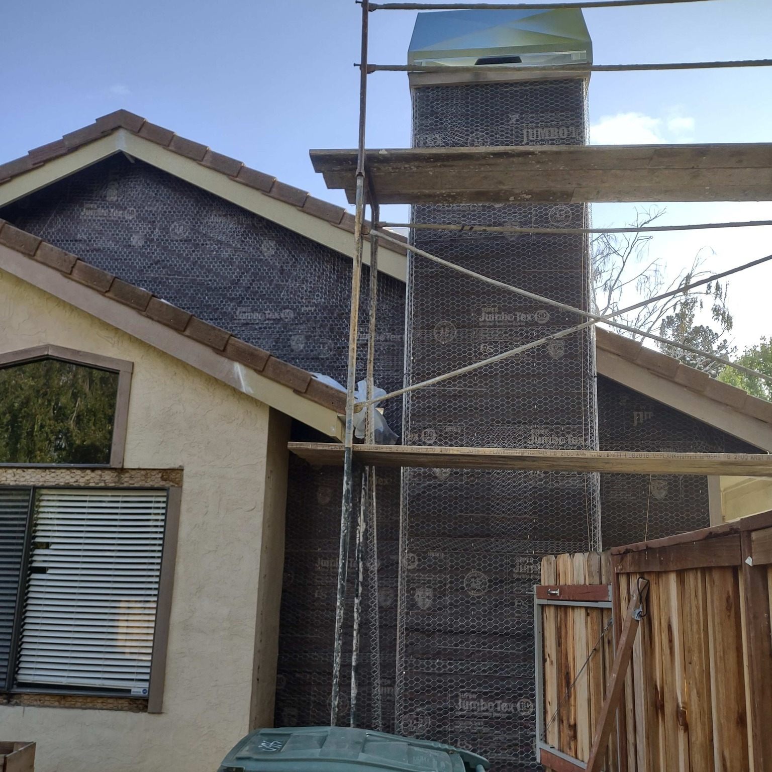 Chimney stucco repair with scaffolding